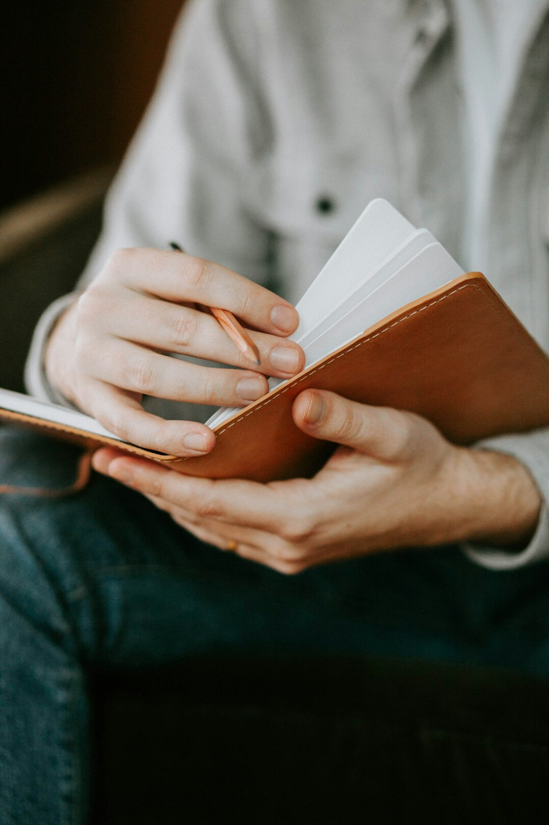 person writing notes in notebook